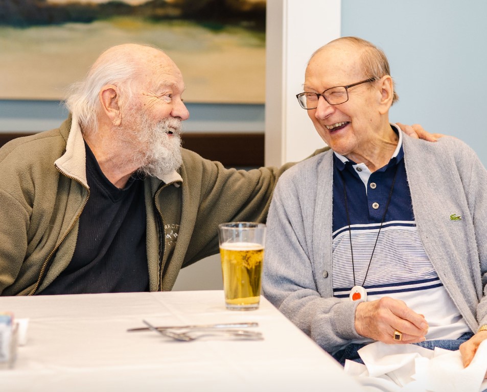 Senior man seated and laughing over beers